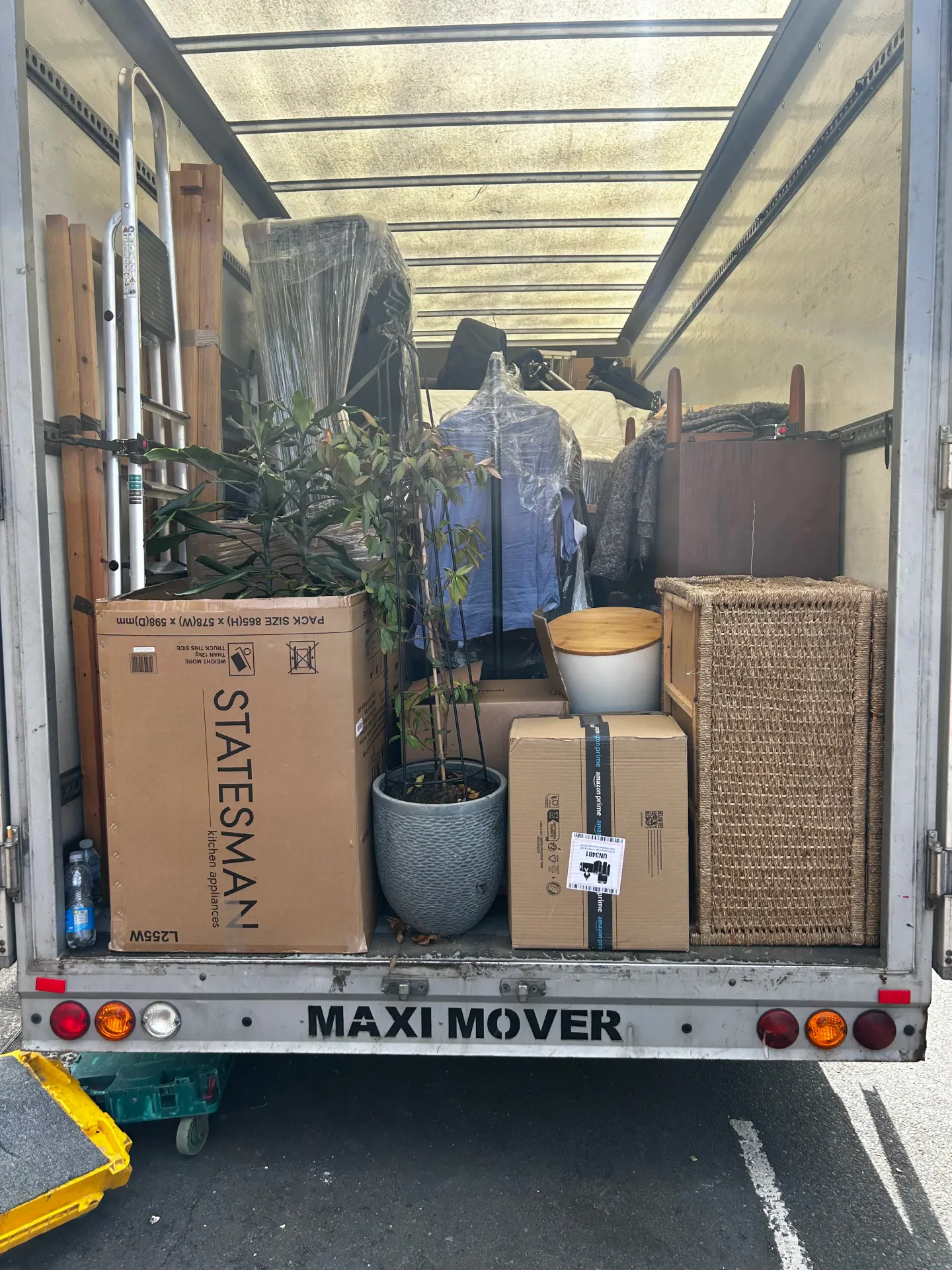 Removals van loaded with boxes, wrapped furniture and a potted tree for a house move
